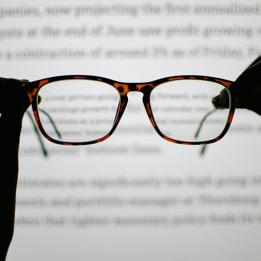 A pair of glasses hovers before a screen with words